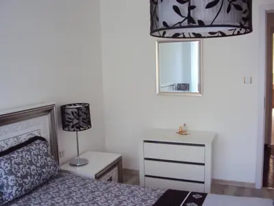 a bedroom with a bed and a lamp and a dresser at Apartment Alyosha in Burgas City