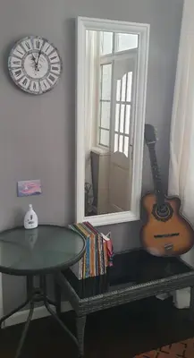 a room with a clock and a guitar and a table at AT Home in Burgas City