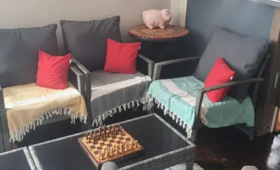 a room with a couch and two chairs and a table at AT Home in Burgas City