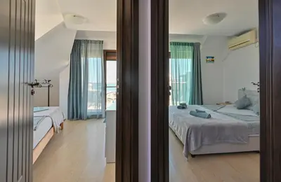 a bedroom with two beds and a balcony at Via Sunride 1 - Maisonette Apartment by the sea in Sozopol