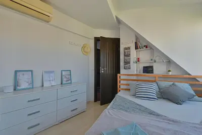 a white bedroom with a bed and a staircase at Via Sunride 1 - Maisonette Apartment by the sea in Sozopol