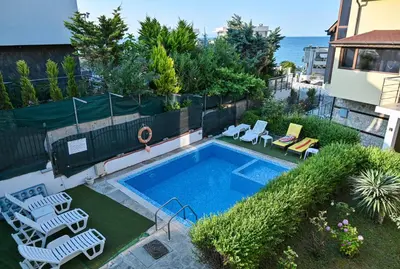 a swimming pool with two lawn chairs at Via Sunride 1 - Maisonette Apartment by the sea in Sozopol