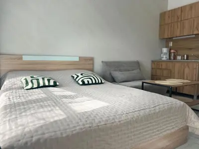 a bedroom with a bed with two pillows and a chair at Sol e Mar Private Apartment in Sunny Beach