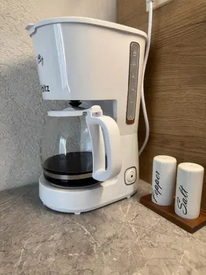 a coffee maker sitting on a counter next to two cups at Sol e Mar Private Apartment in Sunny Beach
