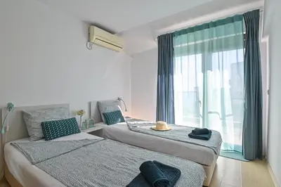 two beds in a room with a window at Via Sunride 2 - Maisonette Apartment by the sea in Sozopol