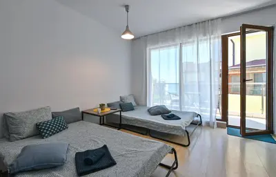 a living room with two beds and a large window at Via Sunride 2 - Maisonette Apartment by the sea in Sozopol