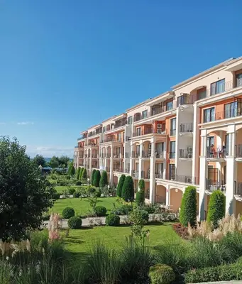 an apartment building with a garden in the foreground at Апартамент в отеле Premier Fort Beach in Sveti Vlas