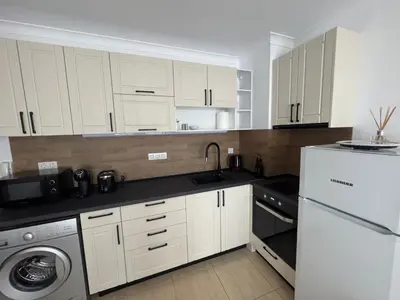 a kitchen with white cabinets and a sink and a dishwasher at Arena I by the Sea in Sveti Vlas