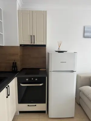 a kitchen with a white refrigerator and a stove at Arena I by the Sea in Sveti Vlas