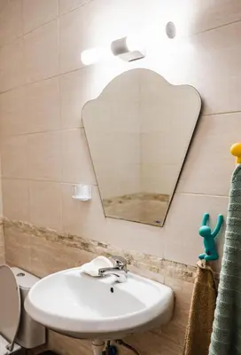 a bathroom with a sink and a heart shaped mirror at Апартамент Морски уют in Burgas City