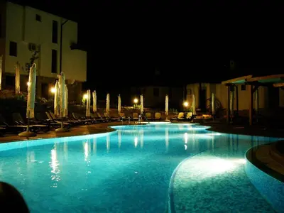 a large swimming pool with blue water at night at Dream apartment in sunny beach in Kosharitsa