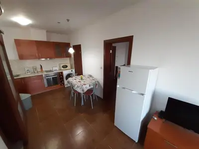 a kitchen with a table and a white refrigerator at Dream apartment in sunny beach in Kosharitsa