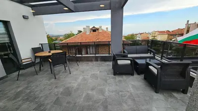 a patio with chairs and tables on a balcony at Холидей Обзор-Стая in Obzor