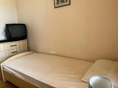 a small bedroom with a bed and a tv at Paradise apartment Sozopol in Sozopol