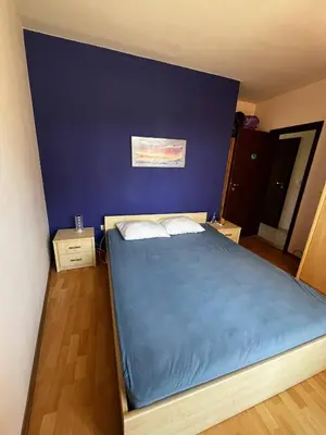 a bedroom with a bed with a blue wall at Paradise apartment Sozopol in Sozopol