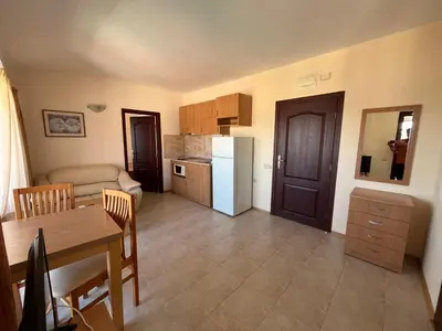 a kitchen and dining room with a table and a kitchen and a room at Rose Village Apartment in Sunny Beach