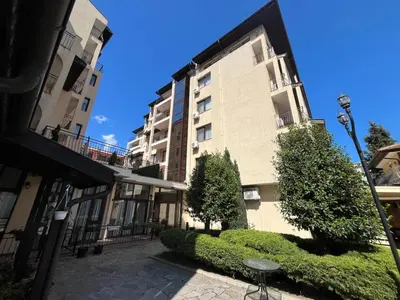 a large apartment building with bushes in front of it at Rose Village Apartment in Sunny Beach