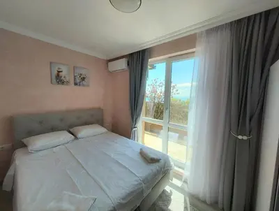 a bedroom with a bed and a large window at Sofi's Harmony in Burgas City