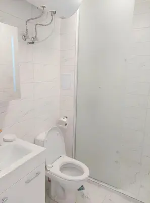 a white bathroom with a toilet and a sink at Sofi's Harmony in Burgas City