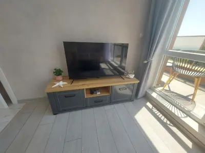 a flat screen tv sitting on top of a wooden entertainment center at Sofi's Harmony in Burgas City