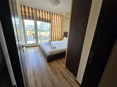 a bedroom with a bed and a large window at Sea View Dune Apartment in Sunny Beach