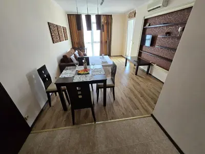 a dining room and living room with a table and chairs at Sea View Dune Apartment in Sunny Beach