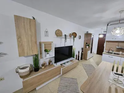 a living room with a flat screen tv on a wall at Tropical Chic for Two, Basement Studio Escape by Flat Mаnager in Ravda