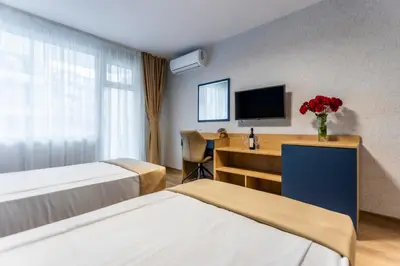 a hotel room with two beds and a television at Hotel Laguna SPA in Sveti Vlas