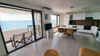 a kitchen and dining room with a view of the ocean at Под наем 4-стаен Апартамент с Изумителна фронтална гледка море, Sun Coast resort Свети Влас in Sveti Vlas