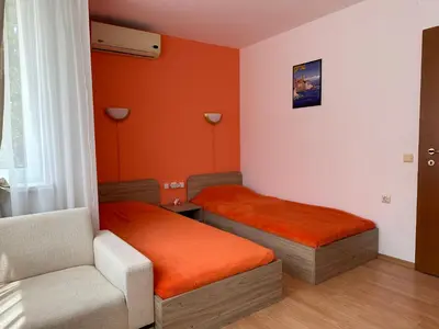 a small room with two beds and a chair at The Sunny Spot in Sunny Beach