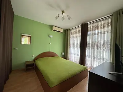 a green bedroom with a bed and a window at The Sunny Spot in Sunny Beach