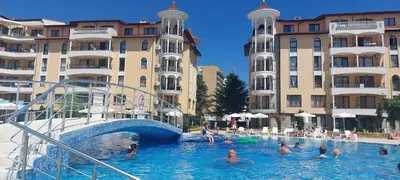 a group of people in a swimming pool with buildings at Royal sun in Sunny Beach