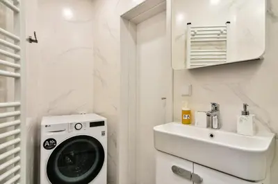 a bathroom with a washing machine and a sink at City center 2BR next to Sea in Varna City