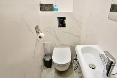 a white bathroom with a toilet and a sink at City center 2BR next to Sea in Varna City