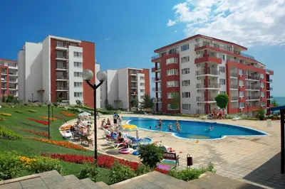 a group of people sitting around a swimming pool at Marina and Panorama Deluxe Apartments in Burgas City