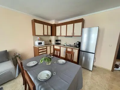 a kitchen with a table and a stainless steel refrigerator at Sofronii Pomorie Residence in Pomorie