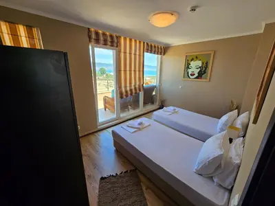 a hotel room with two beds and a window at Sea View Luxury Penthouse in Sunny Beach