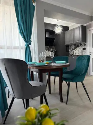 a dining room with a wooden table and green chairs at Sea Sun in Burgas City
