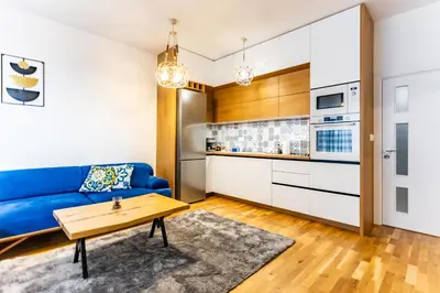 a living room with a blue couch and a table at Arena MALL Galleria Securities Parking 3 in Burgas City