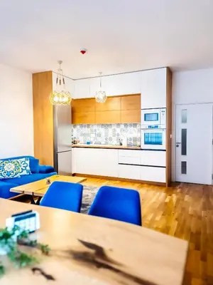 a kitchen and dining room with blue chairs and tables at Arena MALL Galleria Securities Parking 3 in Burgas City