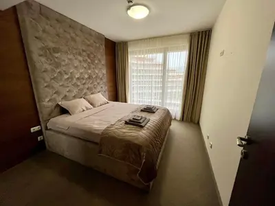 a bedroom with a large bed with a large window at Platinum apartment in Bŭnzareto
