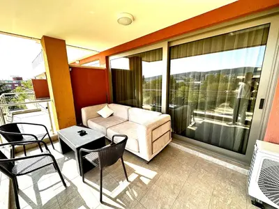 a balcony with a couch and a table and chairs at Platinum apartment in Bŭnzareto