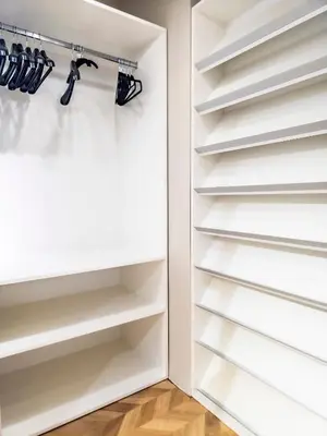 a walk in closet with white shelves at Arena MALL Galleria & Parking 4 in Burgas City