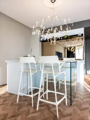 a dining room with white stools and a table at Arena MALL Galleria & Parking 4 in Burgas City