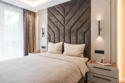 a bedroom with a large bed with a large headboard at City Center Luxury Apartments in Varna City