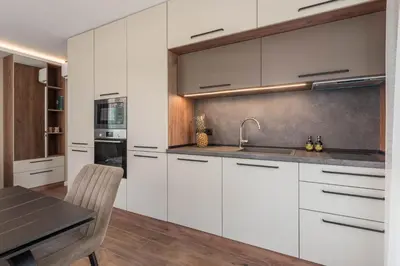 a kitchen with white cabinets and a table at City Center Luxury Apartments in Varna City