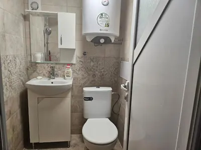 a small bathroom with a toilet and a sink at Малко студио в центъра на град Бургас II in Burgas City