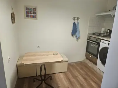 a small kitchen with a table and a stove at Малко студио в центъра на град Бургас II in Burgas City