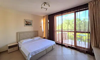 a bedroom with a bed and a large window at Studio for rent Cascadas in Sunny Beach