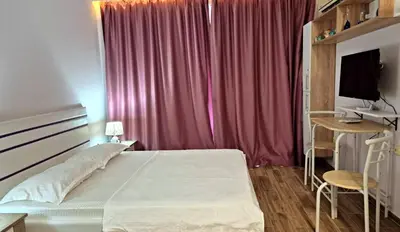 a bedroom with a bed and a pink curtain at Studio for rent Cascadas in Sunny Beach